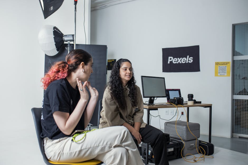 Two women collaborating in a well-equipped photography studio environment.